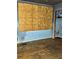 Bedroom featuring a boarded up window, damaged walls, and hardwood floors in need of repair at 1405 Mote Rd, Covington, GA 30016