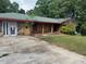 Exterior of the home with a brick and stone facade, covered porch, and dated landscape at 1405 Mote Rd, Covington, GA 30016