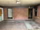 Unfinished living room with a brick accent wall, paint swatches, and unfinished ceilings at 1405 Mote Rd, Covington, GA 30016