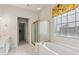 Bright bathroom features a soaking tub and glass-enclosed shower next to a window with a floral valance at 1815 Montcliff Dr, Cumming, GA 30041