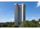 High-rise building with balconies in a residential area surrounded by lush greenery against a blue sky at 2660 Peachtree Rd # 7F, Atlanta, GA 30305