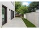 Long and narrow backyard with patio space, low-cut lawn, brick privacy wall, and dark trimmed sliding doors at 420-D Parkway Ne Dr, Atlanta, GA 30308
