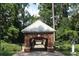 The Cultural Arts Center is framed by trees with a brick entrance and a white roof at 50 Maple St, Roswell, GA 30075