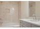 Well-lit bathroom with neutral tile, combined shower and tub, gray vanity with marble countertop, and modern fixtures at 50 Maple St, Roswell, GA 30075