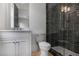 Bathroom features modern vanity, toilet, and glass shower with black horizontal tiling, and recessed lighting at 50 Maple St, Roswell, GA 30075