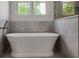 Luxurious bathroom showcases a freestanding bathtub with elegant fixtures and natural light from the window at 50 Maple St, Roswell, GA 30075