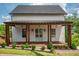 Charming two-story home with a covered front porch, manicured lawn, and brick-lined flower beds at 50 Maple St, Roswell, GA 30075