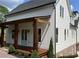 Exterior view featuring a covered porch, manicured landscaping, and grey siding at 50 Maple St, Roswell, GA 30075