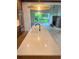Kitchen island featuring stone countertop and sink overlooking great room with brick fireplace at 50 Maple St, Roswell, GA 30075