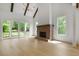 Open living room featuring a vaulted ceiling, wood beams, fireplace, and sliding glass doors to the outside deck at 50 Maple St, Roswell, GA 30075