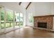 Bright living room showcasing hardwood floors, a brick fireplace, and views of the outdoor landscape at 50 Maple St, Roswell, GA 30075