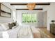 Bright main bedroom featuring hardwood floors, decorative lighting, and a large window for ample natural light at 50 Maple St, Roswell, GA 30075