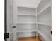 Bright, walk-in pantry features hardwood floors and open, white shelving for organized storage at 50 Maple St, Roswell, GA 30075