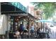 Vibrant restaurant patio with patrons enjoying food and drinks in a lively outdoor setting at 50 Maple St, Roswell, GA 30075