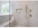 Gorgeous tiled shower with built in bench, tiled floors and shower niche at 50 Maple St, Roswell, GA 30075