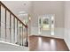 Elegant foyer featuring hardwood floors, staircase with wrought iron railings, and a view of the front door at 105 Tanners Ct, Covington, GA 30016