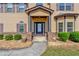 Inviting front entrance with manicured bushes, a stone pathway, and detailed porch columns at 105 Tanners Ct, Covington, GA 30016