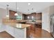 Modern kitchen with granite counters, stainless steel appliances, a central island, and sleek hardwood floors at 105 Tanners Ct, Covington, GA 30016