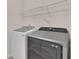 Modern laundry room with updated washer and dryer and white wire shelving at 105 Tanners Ct, Covington, GA 30016