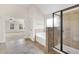 Bright main bathroom with a glass-enclosed shower and tub, seamlessly adjoining the main bedroom at 105 Tanners Ct, Covington, GA 30016