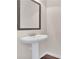 Pedestal sink and mirror in powder room with wood base trim at 105 Tanners Ct, Covington, GA 30016