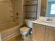 Neutral bathroom with tub/shower combo, single sink vanity, and metal shelving unit at 14301 Waldrop Cv, Decatur, GA 30034