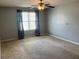 A bedroom with a ceiling fan, a large window with curtains, and carpeted floors at 14301 Waldrop Cv, Decatur, GA 30034
