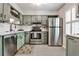Bright kitchen with stainless steel appliances, green cabinets and light countertop at 2474 Lehaven Dr, Tucker, GA 30084