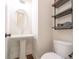 Bathroom featuring a pedestal sink, oval mirror, wood-look flooring, and industrial style shelving unit at 915 Katie Kerr Drive, Decatur, GA 30030