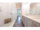 Bathroom featuring a double vanity, tiled shower, and wood bench at 915 Katie Kerr Drive, Decatur, GA 30030