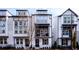 Modern townhome with white brick and gray siding, complemented by black window trim and wrought iron fence at 915 Katie Kerr Drive, Decatur, GA 30030