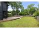 Spacious backyard with a wooden fence, lush green grass, mature trees, and a deck at 2824 Tupelo Se St, Atlanta, GA 30317