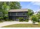 Stylish two-story home with dark siding, green lawn and a paved driveway surrounded by lush trees at 2824 Tupelo Se St, Atlanta, GA 30317