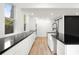 Contemporary kitchen featuring black counters, white cabinets, and stainless steel appliances at 2824 Tupelo Se St, Atlanta, GA 30317