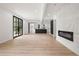 Spacious living room with modern fireplace, kitchen and light wood-look floors with floor to ceiling doors at 2824 Tupelo Se St, Atlanta, GA 30317