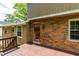 View of a brick house exterior and backyard deck at 440 Ohern Ct, Stone Mountain, GA 30088