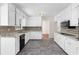 Charming kitchen with white cabinets, dark backsplash, and modern appliances at 440 Ohern Ct, Stone Mountain, GA 30088