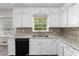 Close-up of kitchen with white cabinets, stainless steel sink, and black dishwasher at 440 Ohern Ct, Stone Mountain, GA 30088