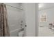Bright bathroom featuring a bathtub with shower combo, toilet, and view into a Bedroom at 485 St Annes Pl, Covington, GA 30016
