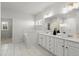 This bright bathroom features a double vanity, a large mirror, white cabinets, and a separate tub at 485 St Annes Pl, Covington, GA 30016