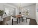 Contemporary dining area with elegant light fixture, white wainscoting, and dark hardwood floors at 485 St Annes Pl, Covington, GA 30016