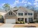 Charming two-story home featuring a combination of brick and stone, attached garage, and a well-manicured front lawn at 485 St Annes Pl, Covington, GA 30016