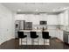 Bright kitchen with stainless appliances, white cabinets, and large island with bar stool seating at 485 St Annes Pl, Covington, GA 30016