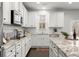 Bright kitchen featuring white cabinetry, granite countertops, stainless steel appliances, and an open layout at 485 St Annes Pl, Covington, GA 30016