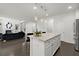 Well-appointed kitchen with a granite island and stainless appliances open to the living room with vaulted ceilings and lots of light at 485 St Annes Pl, Covington, GA 30016