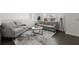 This living room features grey couches, an indoor plant, a decorative rug, and a coffee table at 485 St Annes Pl, Covington, GA 30016