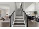 Elegant staircase with dark wood steps and railing, offering a view of the dining room and open-concept living space at 485 St Annes Pl, Covington, GA 30016