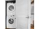 Stacked washer and dryer unit inside a laundry closet with louvered doors at 860 Peachtree Ne St # 909, Atlanta, GA 30308