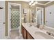 Bathroom with a double sink vanity, wood cabinets, and a view of shower and door at 3125 Flatbottom Dr, Dacula, GA 30019