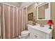 Bathroom features a vanity with a white cabinet, a sink, and a striped shower curtain at 3125 Flatbottom Dr, Dacula, GA 30019